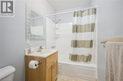 Bathroom featuring a single vanity with wood cabinetry, a white countertop, and a mirrored medicine cabinet - 143 David Street, Kitchener, ON 