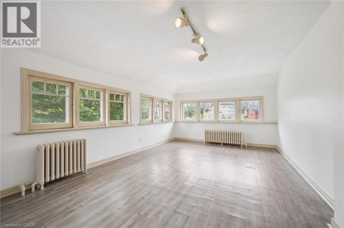 Light wood-finish flooring with track lighting and multiple windows - 143 David Street, Kitchener, ON 
