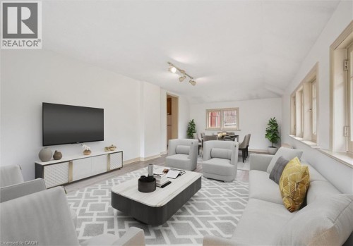 Bright interior space featuring a light-colored rug, multiple windows, and track lighting - 143 David Street, Kitchener, ON 