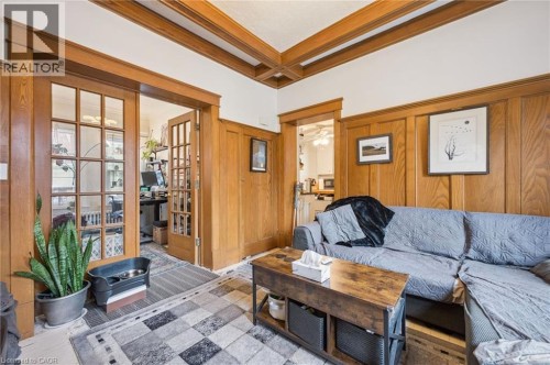 Wood-paneled wall accents, wood-finish coffered ceiling, and wood-finish French doors - 143 David Street, Kitchener, ON 
