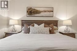 Neutral wall tones complement a wood-finish headboard and coordinating nightstands - 