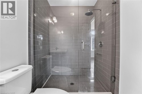 Glass-enclosed shower featuring subway tile surround, rain shower head, and polished chrome fixtures - 1169 E Garner Road E Unit# 66, Ancaster, ON 