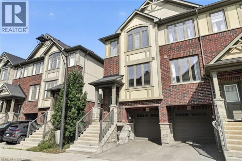 Brick and stucco exterior with multiple windows, an integrated garage, and an inviting front porch - 1169 E Garner Road E Unit# 66, Ancaster, ON 