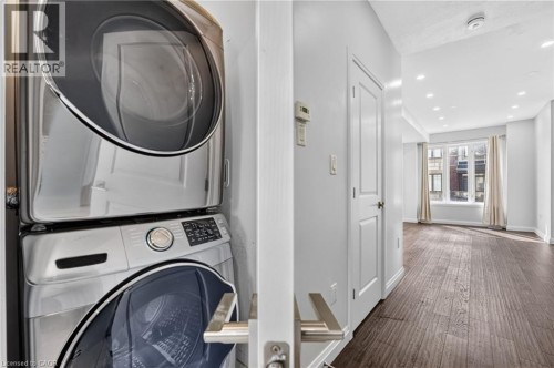 Full-size stacked laundry appliances, recessed lighting, wood-finish flooring, and a window with architectural details - 1169 E Garner Road E Unit# 66, Ancaster, ON 