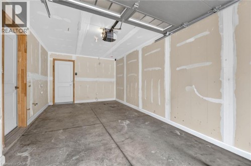 Unfinished garage interior with concrete flooring and exposed ceiling joists - 1169 E Garner Road E Unit# 66, Ancaster, ON 