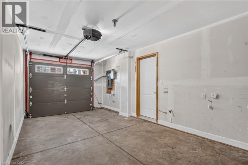 Concrete flooring with exposed ceiling joists and an automatic garage door opener - 1169 E Garner Road E Unit# 66, Ancaster, ON 