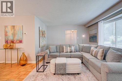 Parquet wood flooring, neutral wall tones, large windows with blinds, recessed lighting, and a broad coved ceiling - 3158 Palmer Drive, Burlington, ON 