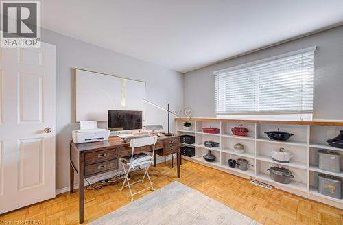 Parquet wood-finish flooring, built-in shelving with wood-finish tops, white paneled door, and a window with horizontal blinds - 3158 Palmer Drive, Burlington, ON 