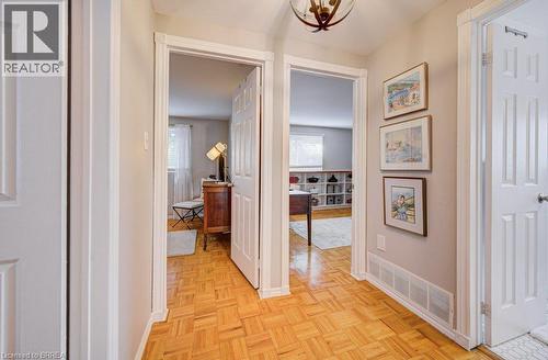 Wood-finish flooring throughout, white trim, and a semi-flush mount ceiling fixture - 3158 Palmer Drive, Burlington, ON 