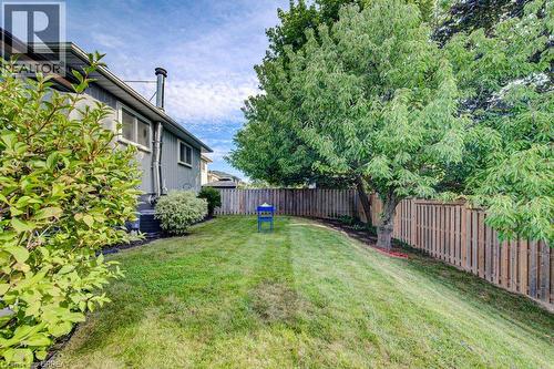 Expansive grassy yard with mature trees, established shrubbery, and a wood privacy fence - 3158 Palmer Drive, Burlington, ON 