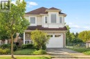 Two-story residence featuring a brick facade, siding, a prominent bay window, and an attached two-car garage - 67 Apple Tree Drive, Kitchener, ON 