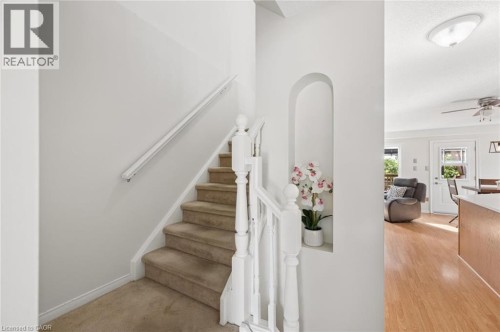 Carpeted staircase with white balusters - 67 Apple Tree Drive, Kitchener, ON 