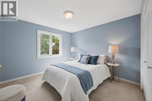 Plush carpeting, a single window with white trim, light blue wall paint, and a built-in closet with bifold doors - 67 Apple Tree Drive, Kitchener, ON 