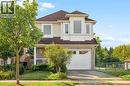Two-story residence featuring a brick facade, siding, a prominent bay window, and an attached two-car garage - 67 Apple Tree Drive, Kitchener, ON 