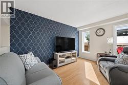 Accent wall featuring a geometric pattern, two windows, and wood-finish flooring - 