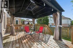 Wood-finish deck with a black gazebo featuring light-toned fabric privacy curtains - 
