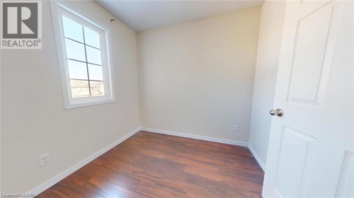 Wood-finish flooring, neutral wall tones, white trim, and a multi-pane window - 11 Sorrento Street, Kitchener, ON 