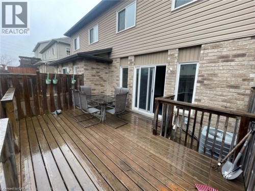 Rear exterior with wood decking, wood fence, brick and siding facade, and sliding glass door - 11 Sorrento Street, Kitchener, ON 