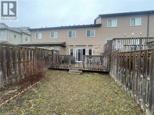 Private backyard featuring a wood deck, wood fencing, and a ground-level patio area - 11 Sorrento Street, Kitchener, ON 
