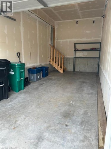 Concrete flooring with a wooden staircase and metal shelving - 11 Sorrento Street, Kitchener, ON 