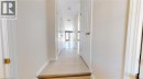 Hallway with light-colored tile flooring, white interior doors, and a wood-finish step - 11 Sorrento Street, Kitchener, ON 