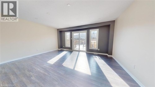 Wood-finish flooring, recessed ceiling lighting, and a sliding glass door with two adjacent windows - 11 Sorrento Street, Kitchener, ON 