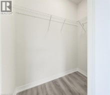 Walk-in closet with wire shelving and wood-finish flooring - 