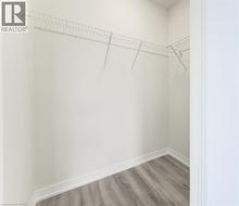 Walk-in closet with wire shelving and wood-finish flooring - 