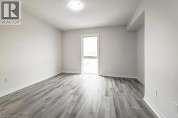 Recessed lighting, wood-finish flooring, white trim, and a window with natural illumination - 