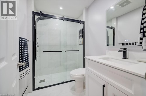 White vanity with integrated sink, black-finish faucet, and coordinating cabinet hardware - 573 Robert Ferrie Drive, Kitchener, ON 
