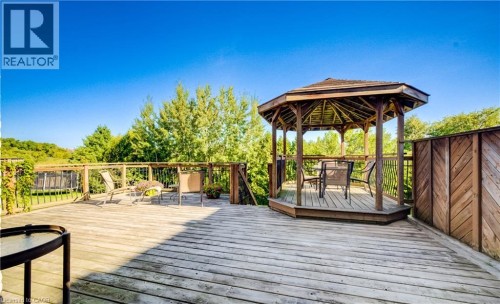 Expansive wood deck with a built-in gazebo, wood railing, and privacy panel - 573 Robert Ferrie Drive, Kitchener, ON 
