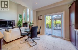 Soaring ceiling with recessed lighting, prominent arched and vertical windows, fireplace feature, built-in cabinetry, and sliding glass door leading to an exterior deck with a gazebo - 