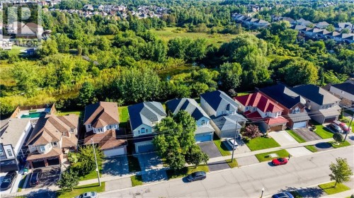 Residential street with multiple homes featuring varied architectural styles and integrated garages - 573 Robert Ferrie Drive, Kitchener, ON 