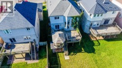 Expansive green lawn, multi-level wooden deck, and a hexagonal gazebo with a shingled roof - 
