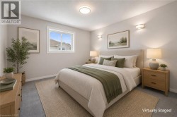 Recessed lighting, wall sconces, window with white trim, light gray wall color, and gray carpeting - 