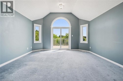 Vaulted ceiling room with an arched glass door, two rectangular windows, and a ceiling-mounted light fixture - 426 Hidden Creek Drive, Kitchener, ON 