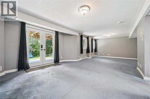 Expansive lower-level space featuring light gray walls, plush gray carpeting, and multiple windows - 426 Hidden Creek Drive, Kitchener, ON 