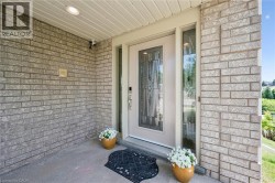 Brick exterior with a recessed entryway, featuring a panel-inlaid door with decorative glass, and a side light - 