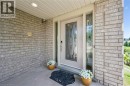 Brick exterior with a recessed entryway, featuring a panel-inlaid door with decorative glass, and a side light - 426 Hidden Creek Drive, Kitchener, ON 