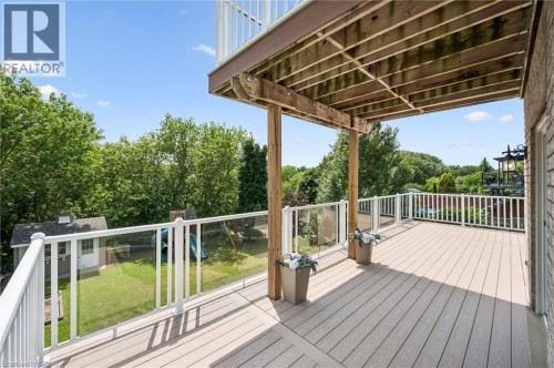 Expansive outdoor deck featuring wood-finish flooring, white railings with glass panels, and a full ceiling overhead - 426 Hidden Creek Drive, Kitchener, ON 