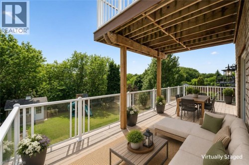 Expansive outdoor deck featuring composite decking, glass panel railings, and wood support beams - 426 Hidden Creek Drive, Kitchener, ON 