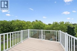 Exterior deck with composite flooring, white railing, and glass paneling - 