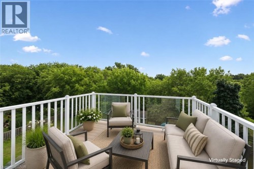 Expansive outdoor terrace featuring composite decking, white railing, and clear panel balustrade - 426 Hidden Creek Drive, Kitchener, ON 