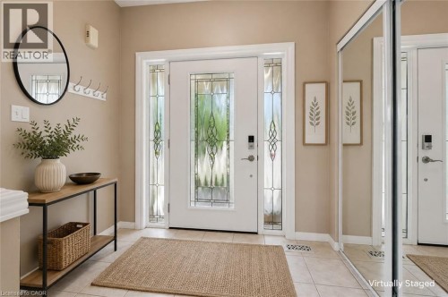 Entryway with ceramic tile flooring, a white front door featuring decorative glass, and coordinating sidelight panels - 426 Hidden Creek Drive, Kitchener, ON 
