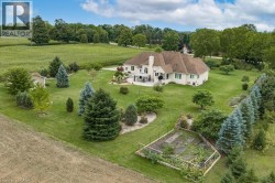 Expansive green lawn with mature trees and a dedicated garden area - 