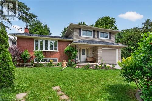 Brick and siding exterior with stone accents, bay window, attached garage, covered entryway, and front lawn - 114 Shuh Avenue, Kitchener, ON 