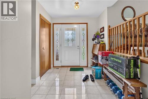 Foyer with tile flooring, a solid wood door with decorative glass inserts, and a light wood-finish staircase - 114 Shuh Avenue, Kitchener, ON 