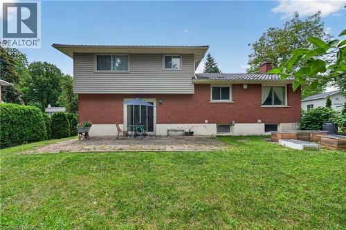 Expansive green lawn with a paver patio, red brick and siding exterior, and a sliding glass door - 114 Shuh Avenue, Kitchener, ON 