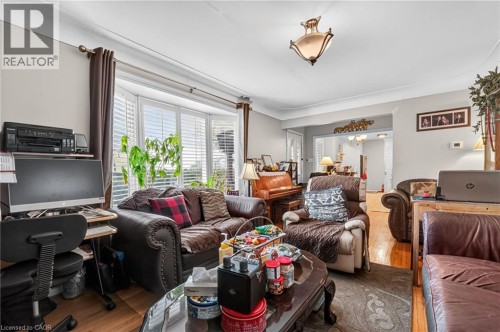Recessed bay window with interior plantation shutters, wood-finish flooring, crown molding, and an ornate semi-flush mount ceiling fixture - 121 Panin Road, Burlington, ON 