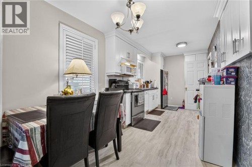 Kitchen featuring white cabinetry, light-toned wood-finish flooring, recessed lighting, and a window with plantation shutters - 121 Panin Road, Burlington, ON 